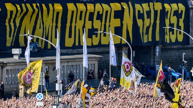 Anhänger der SG Dynamo Dresden nehmen an einem Fanmarsch zum Stadion teil und laufen am Terrassenufer entlang.