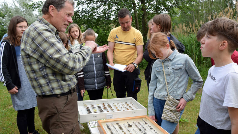 Herbert Schnabel (l.) erklärt Kindern, welche Insekten auf einer Wiese am Gondelteich leben. Bernd Latta (in Gelb) gibt ebenfalls Informationen.