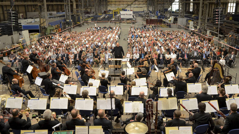 Das Orchester besucht die Industrie-Halle – erstmals unter neuem Namen: Zum Rime-Freyler-Konzert Ende Juni hat sich die Elbland Philharmonie neben der Singakademie Dresden auch den Konzertchor Riesa und den Jugendchor des Werner-Heisenberg-Gymnasiums eing