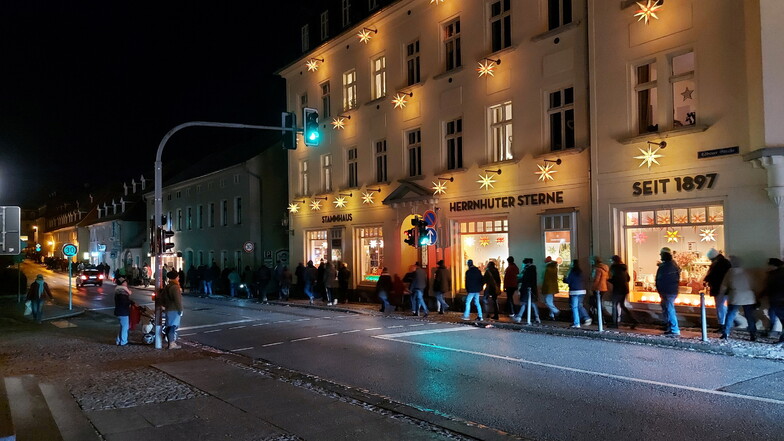 Teilnehmer des Spaziergangs gegen die Corona-Maßnahmen laufen vom Herrnhuter Bahnhof kommend die Löbauer Straße entlang in Richtung Zinzendorfplatz.