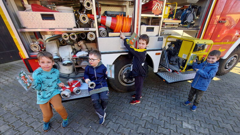 Diese vier Jungen erkunden das Pulsener Löschfahrzeug und wollen in die neue Bambini-Feuerwehr eintreten.
