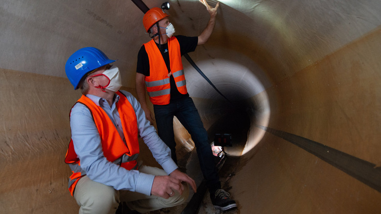 Chef-Stadtentwässerer Ralf Strothteicher und Bauleiter Martin Lehmann inspizieren den frisch sanierten Abwassertunnel an der Flügelwegbrücke.