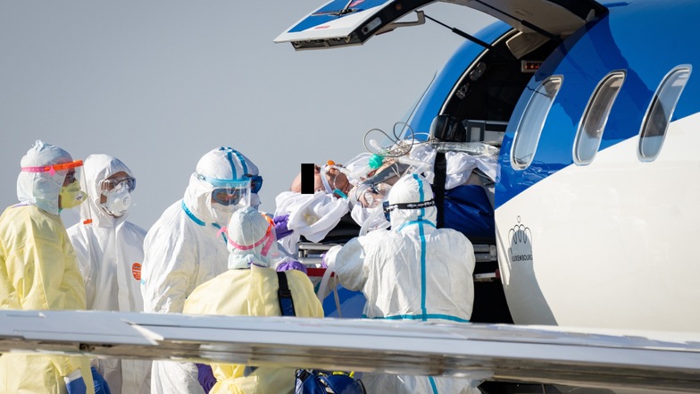 Ein schwer kranker Covid-19-Patient aus Frankreich wird auf dem Flughafen Dresden aus einem Ambulanzflugzeug in den Krankenwagen gehoben.
