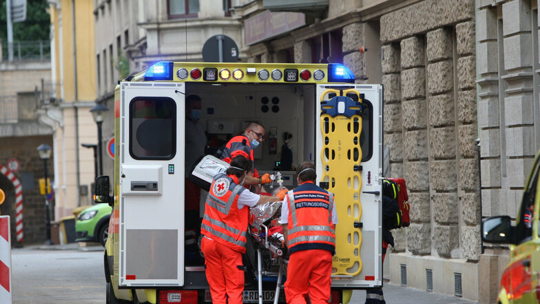 Rettungskräfte tragen die Seniorin zum Krankenwagen.