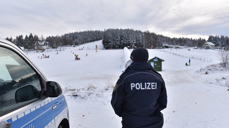 Polizist am Skihang in Altenberg. Die Gäste hatten Kennzeichen wie DD, BZ und MEI.