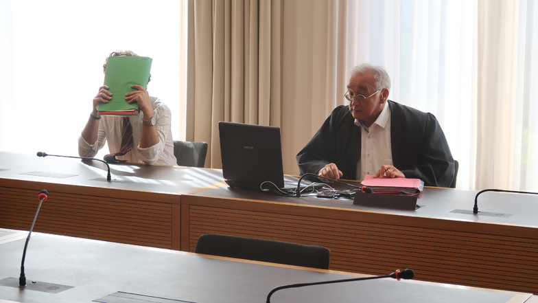 Weißes Hemd, Krawatte, das Gesicht hinter einer Akte versteckt - so saß Gerd E. am Mittwoch im Landgericht Dresden. Neben ihm sein Verteidiger Michael Flintrop.