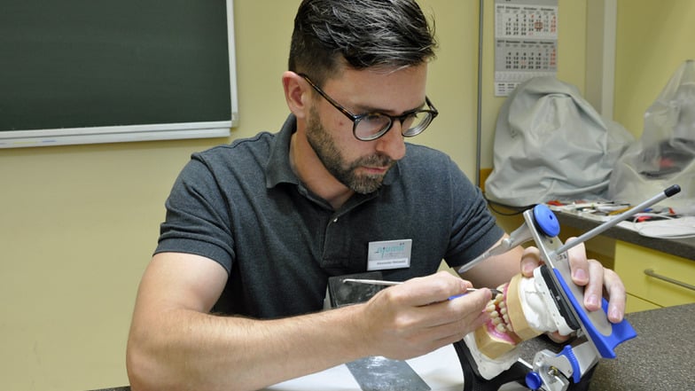 Zahntechnikermeister Alexander Meiwald demonstriert die Aufstellung einer Totalprothese.