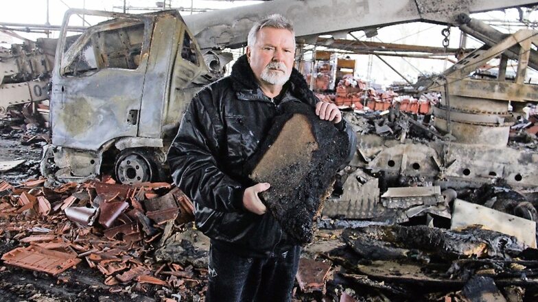 Ein Brand hat eine Lagerhalle von Dachdecker Egon Gumprich verwüstet. Unter anderem wurde das Kranauto der Firma zerstört. Auch das dort gelagerte Material ist hin, zum Beispiel Dämmung, von der der Chef ein verkohltes Stück zeigt.