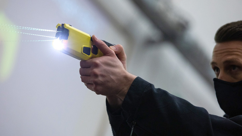 Ein Polizeibeamter demonstriert einen Schuss mit einem Distanzelektroimpulsgerät (DEIG oder auch Taser).