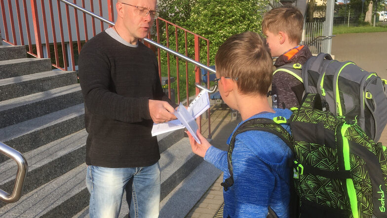 An der Großenhainer Grundschule Am Schacht nimmt Lehrer Mario Janta die Gesundheitserklärung der Schüler entgegen.