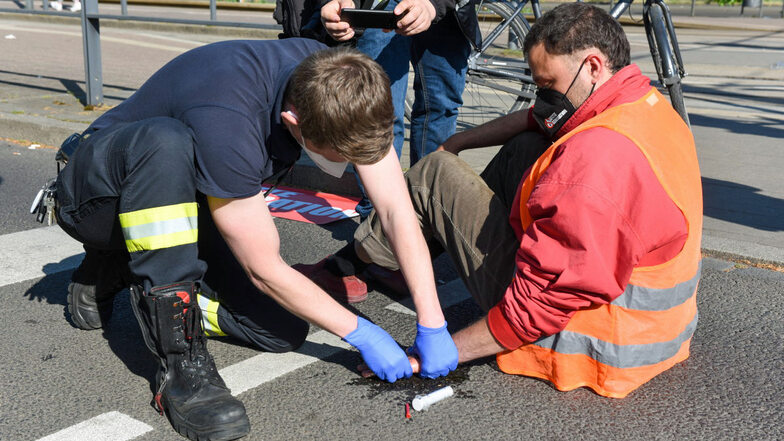 Ein Rettungssanitäter von der Feuerwehr Leipzig löst eine festgeklebte Hand mit Olivenöl.