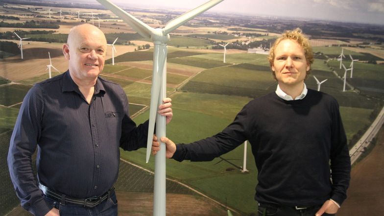 Die beiden Geschäftsführer Frank Bündig (links) und Matthias Bleil stehen vor einer Aufnahme eines Windenergieparks, für den die Firma Energieanlagen Frank Bündig das Projekt erstellt hat.