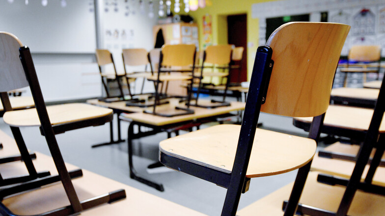 Stühle stehen in einem Klassenzimmer auf den Tischen. So wird es in Sachsen auch eine Weile bleiben, denn der Schulbetrieb ist wegen des Coronavirus ab Montag vorerst eingestellt.