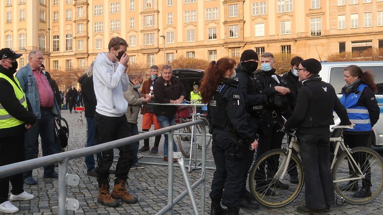 Das Foto zeigt Sascha W. (mit Rad) am 19. April 2021 auf dem Altmarkt vor einer Querdenker-Demo mit Initiator Marcus Fuchs (weißes Oberteil). An dem Tag wurde er von der Polizei wegen seiner fehlenden Maske nicht auf die Demo gelassen.
