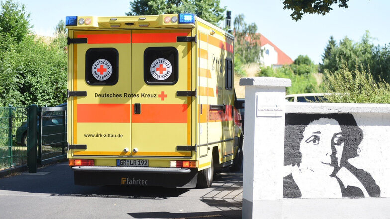 Ein Krankenwagen fährt am Donnerstagnachmittag zur Schule in Zittau. Dort ging es Kindern nach dem Mittagessen schlecht.