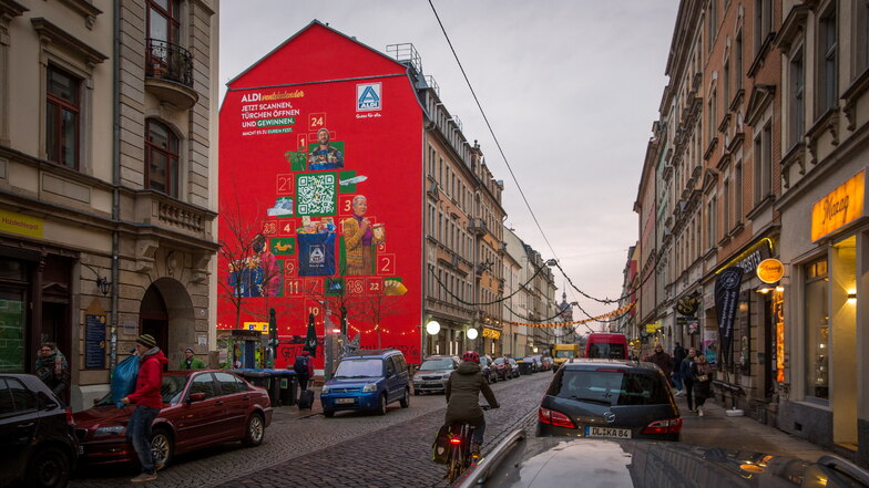 Auffällig und nicht genehmigt: eine riesige rote Werbung an einer Hauswand in Dresden-Neustadt.