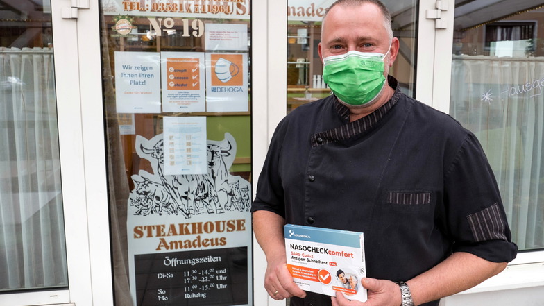 Dirk Kretschmer, Inhaber des "Steakhouse Amadeus" in der Kopernikusstraße in Görlitz, vor seinem Restaurant. Er hält einen Covid-Test in der Hand, da auch direkt vor dem Restaurant getestet werden kann.