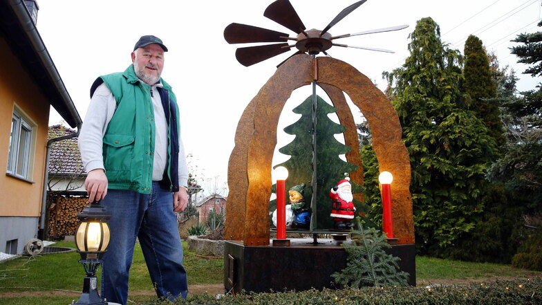 Tüftler Frank Richter neben seiner Riesenpyramide im Garten am Brackenweg in Schwepnitz. Noch bis ins neue Jahr soll sie sich drehen.