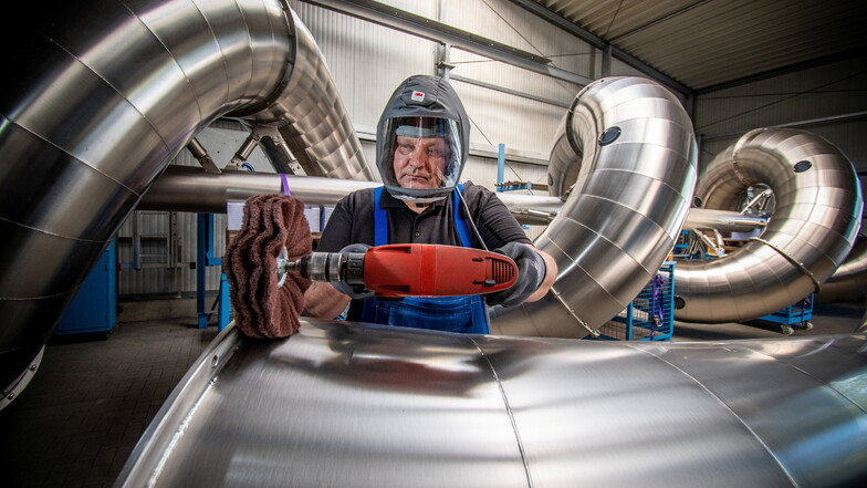 Waldemar Tscherkaschin schützt sich in der Firma Atlantics bei Arbeiten an einer Rutsche mit einem ganz besonderen Helm. Der hat eine eingebaute „Klimaanlage“.