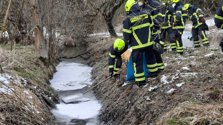 Feuerwehrleute beseitigten am Freitagnachmittag Ölflecken auf einem Nebenbach der Großen Röder in Bretnig.