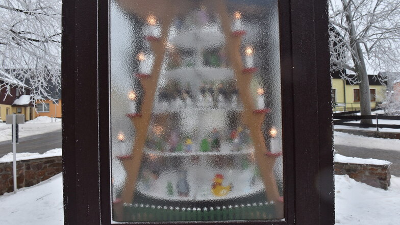 Hinter der vereisten Scheibe ist die Weihnachtspyramide am Bosseplatz in Altenberg nur noch schemenhaft zu erkennen, es wirkt wie Strukturglas.