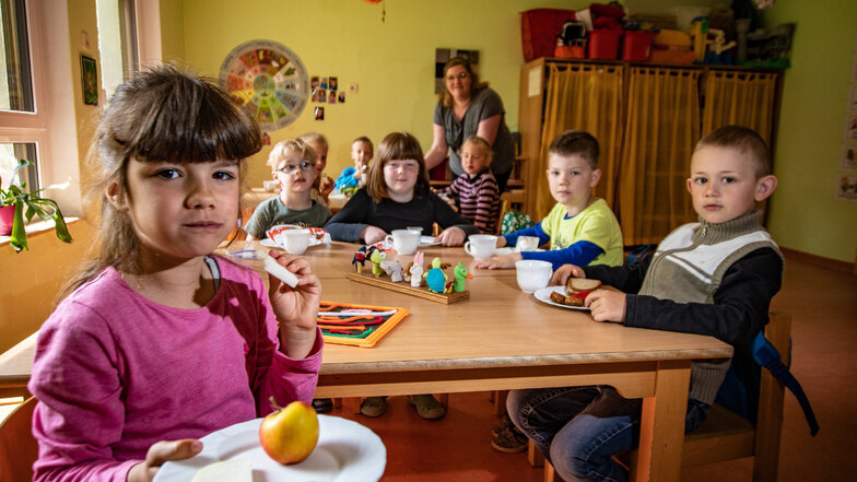Für die Kitas Ostrau gilt ab Juli eine neue Betreuungssatzung, die Vorteile für die Eltern mit sich bringt. Rosalie (vorn) besucht den Kindergarten der „Jahnataler Wiesenstrolche“ in Ostrau. Sie hat gesundes Essen auf dem Teller.