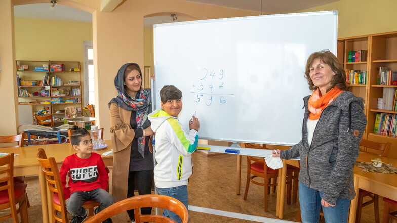 Sajad (links) staunt, was sein großer Bruder Jawad rechnen kann. Ihre Mutter Sofia Abdullahi ist stolz auf ihren großen Sohn, der gerne lernt. Heike Gelke (rechts) unterstützt die Familie bei Behördendingen.