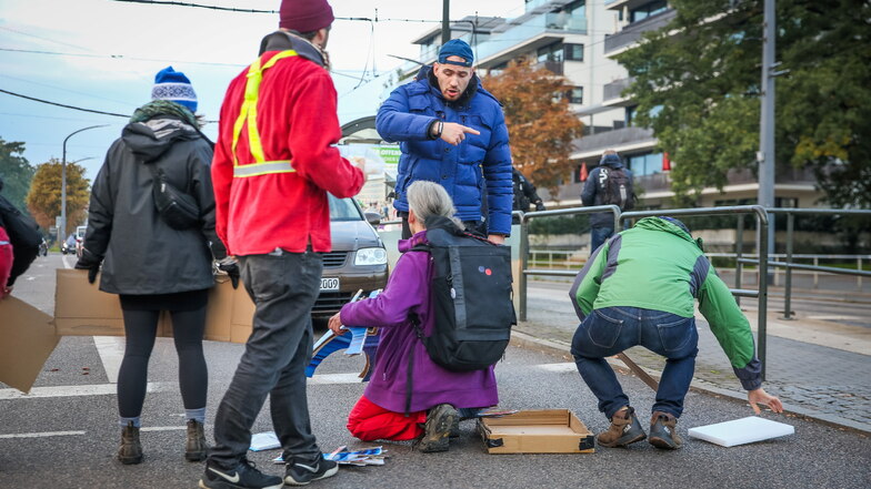 Klimaschutz-Demonstranten blockieren den Verkehr auf der Lennéstraße am Straßburger Platz. Es gibt Diskussionen mit Passanten.