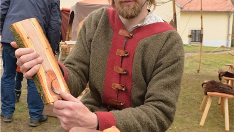 Sebastian Stock aus Tharandt bearbeitet ein Stück Pflaumenholz. Er zeigt das Handwerk des Löffelschnitzens.