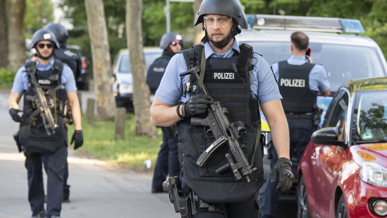 Schwer bewaffnete Polizisten sichern nach einer Schießerei ein Wohngebiet in Darmstadt