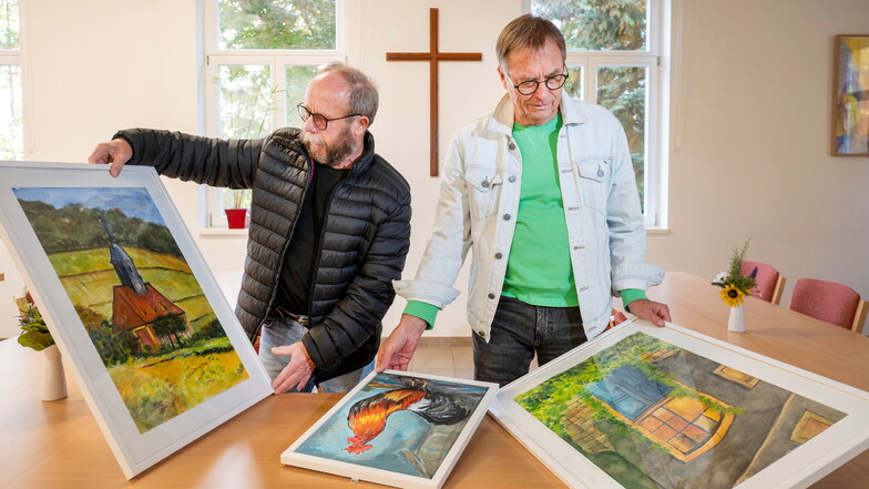 Gunter Hauswald (l.) und Jörg Arnholdt bereiten in der Pfarrscheune in Possendorf die zweite Ausstellung der Bannewitzer Hobbymaler vor.