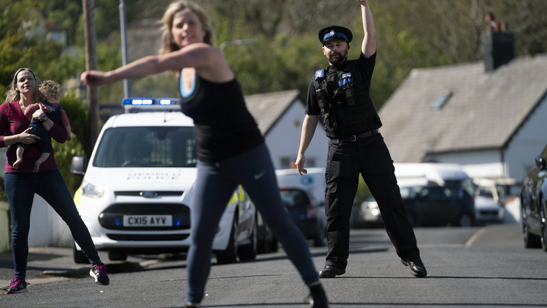 Großbritannien, Prestatyn: Ein Polizist nimmt an einer Tanzstunde teil, die von Anwohnern organisiert wurde. Ziel ist es, sich während des Coronavirus-Ausbruchs fit zu halten und sozialen Kontakt zu haben.