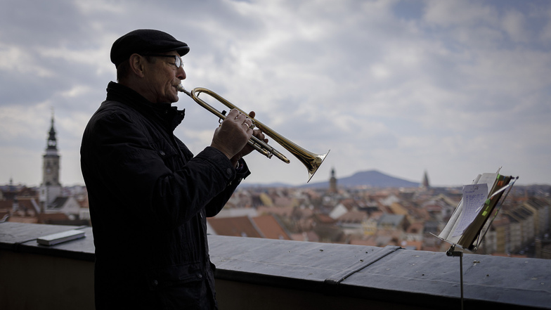 Gotthard Pissang spielt mit seiner Trompete auf der Aussichtsplattform der Peterskirche.