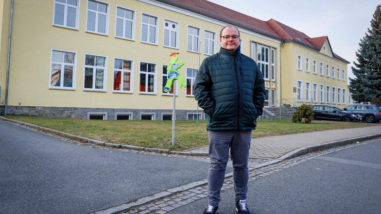 Der Bürgermeister der Gemeinde Räckelwitz, Clemens Poldrack (parteilos), steht vor der Oberschule seiner Gemeinde. Er hofft, dass die Sanierung im Sommer 2024 starten kann. Bis dahin muss noch viel geklärt werden.