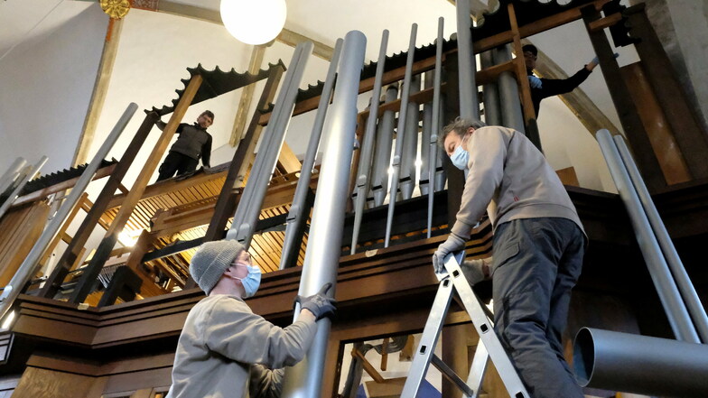 Die Orgelbauer balancieren die Orgelpfeifen behutsam auf den Prospekt. Die längste Pfeife ist 4,80 Meter.