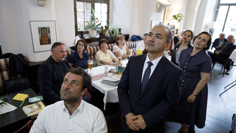 Der Görlitzer OB-Kandidat Octavian Ursu (vorne rechts) verfolgt die Bekanntgabe der Wahlergebnisse ...