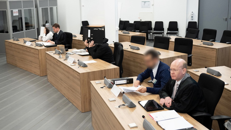 Die Angeklagten im Prozess um den rechtsextremistischen Verlag "Der Schelm" sitzen vor Beginn der Verhandlung in einem Saal des Oberlandesgerichts neben ihren Anwälten.