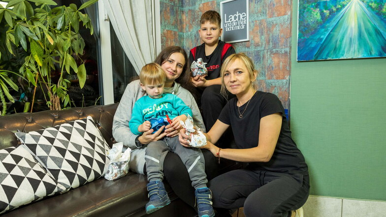 Uliana sitzt mit ihren beiden Söhnen Yurii und Sascha auf einer Couch in Freital. Wegen des Krieges müssen sie Weihnachten außerhalb der Heimat verbringen. Mila Richter (r.) aus Freital unterstützt sie in dieser schweren Zeit.
