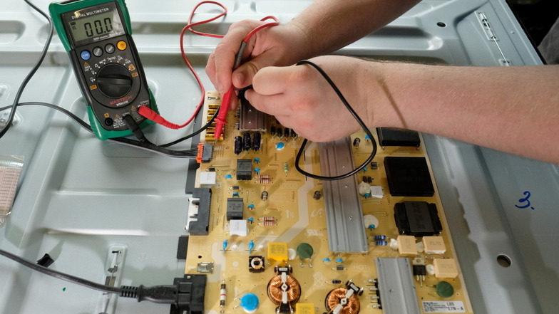 Geht da noch was? Ein Werkstattmitarbeiter ermittelt an  einem Fernsehbildschirm elektronische Messgrößen. Der SAB-Bonus soll Privathaushalte dazu animieren, defekte Elektro- und  Elektronikgeräte reparieren zu lassen.