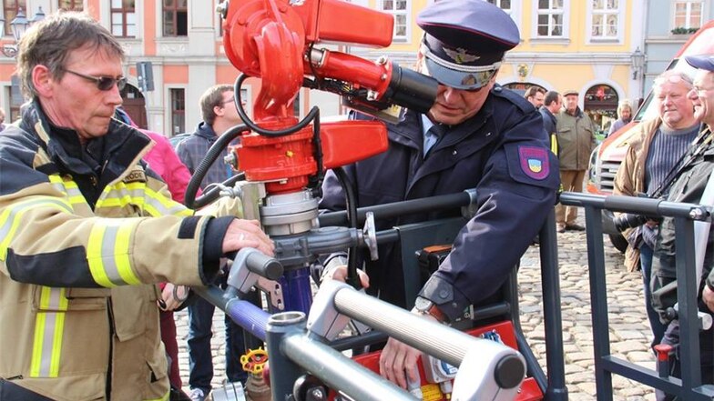 Vorführung der neuen Feuerwehrfahrzeuge auf dem Bautzener Hauptmarkt. Löschgeräte werden am Leiterkorb montiert.