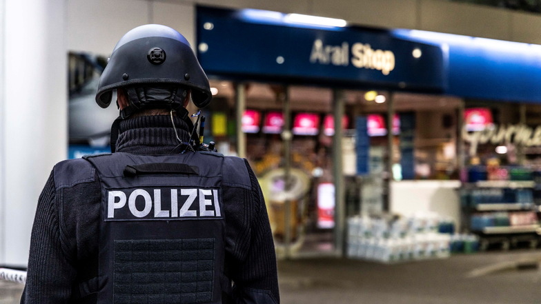 Ein Polizist sichert am frühen Morgen den Tatort, eine Tankstelle in Idar-Oberstein.