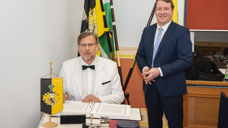 Kai-Uwe Schwokowski schreibt sich ins Goldene Buch der Stadt als neuester Träger der Kleinen Preusker-Medaille ein. Er bekam sie von Oberbürgermeister Sven Mißbach (r.) für seine Verdienste im Ehrenamt und verabschiedete sich vom Stadtrat.