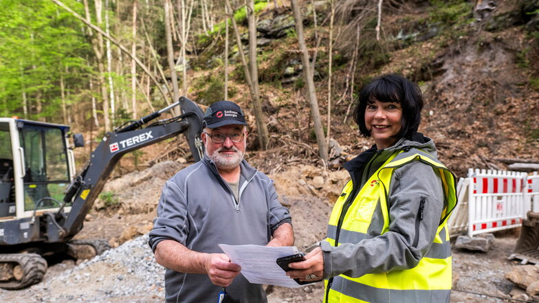 Projektleiterin Petra Klering und Bauleiter Peter Pech von der SachsenEnergie vor dem Felsen im Polenztal, der nach oben durchbohrt werden musste.