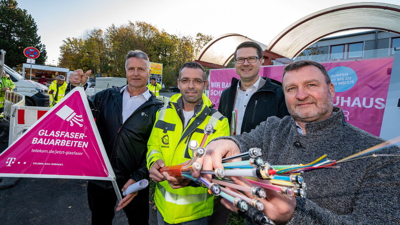Marcel Saupe von Telekom zeigt mit Daniel Bergert ein Bündel Glasfaserkabel. Mit Oberbürgermeister Sven Liebhauser (2.v.r.) und Matthias Patzsch (links) haben sie den Glasfaserausbau gestartet.