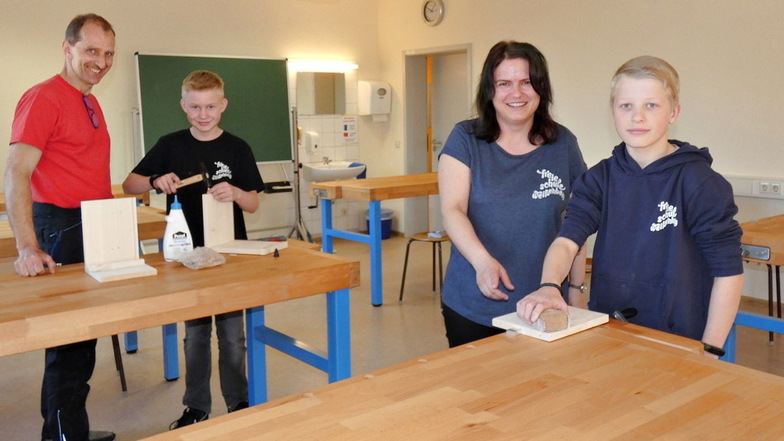 Bastian (vorn, mit Lehrerin Manuela Kasper) und Pierro (hinten, mit Kursleiter Andreas Hofmann) freuen sich über den neuen Werkraum der Freien Schule Weißenberg.