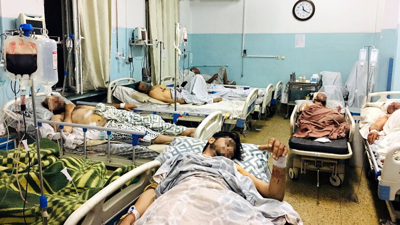Männer, die bei dem tödlichen Anschlag in der Nähe des Flughafens von Kabul verletzt wurden, liegen in einem Krankenhaus.