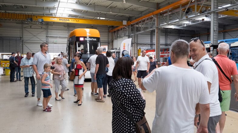 Besucher schauen sich in einer Fertigungshalle um.