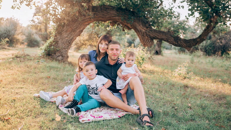 "Wir hatten so viele Träume." Nataliia Bukharina mit ihrem Mann Volodymyr und den Kindern Maja, Marko und Marta im Sommer 2020 auf einer Wiese am Dnipro-Fluss.