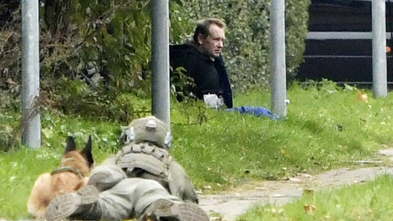 Ein Polizist liegt am Boden und beobachtet Peter Madsen, der nach einem gescheiterten Fluchtversuch auf dem Boden sitzt.