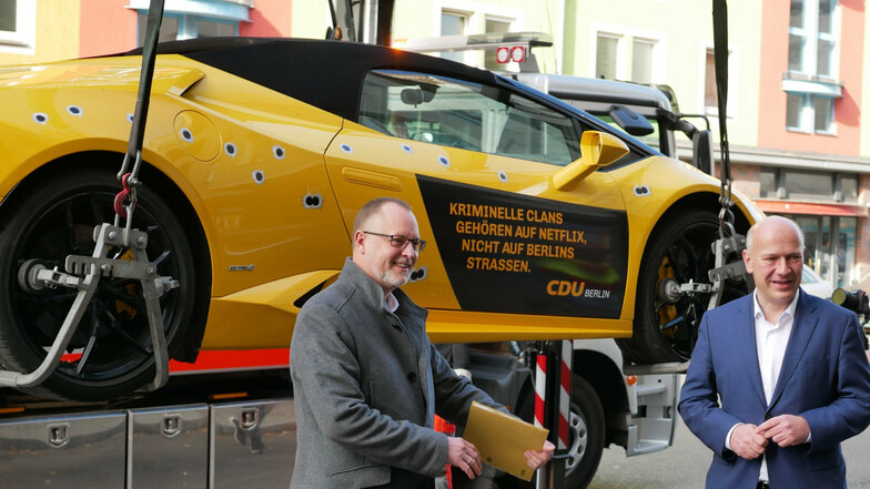 Kai Wegner, CDU-Landeschef (r), und Falko Liecke (CDU, Neuköllns Gesundheitsstadtrat, stehen vor dem gemieteten Lamborghini mit den aufgeklebten Einschusslöchern.